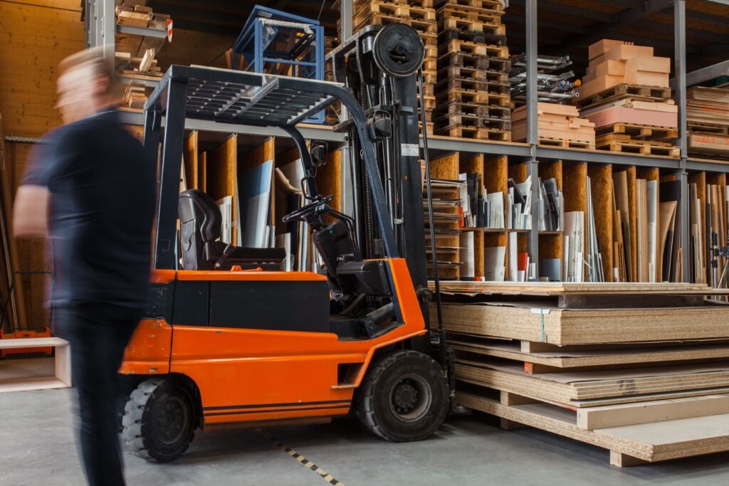 A forklift parked next to some wooden pallets in a warehouse