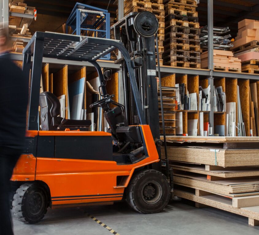 A forklift parked next to some wooden pallets in a warehouse