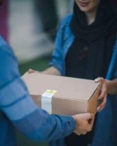 A courier handing over a cardboard box