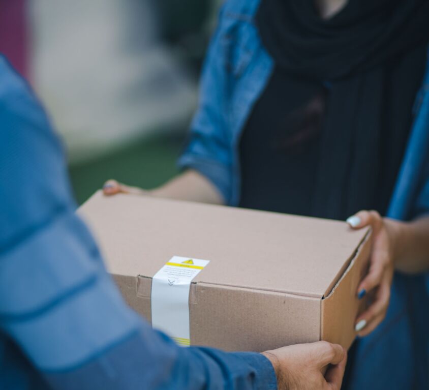 A courier handing over a cardboard box
